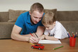 Man and boy drawing on notebook