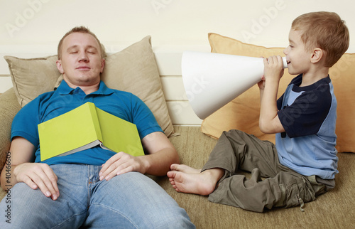Foto: Man sleeping on couch, boy screaming through megaphone Man sleeping on couch, boy screaming through megaphone