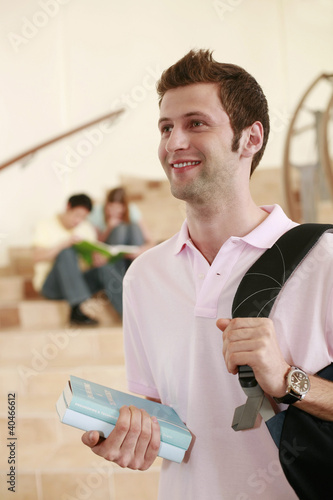 Photo: Man carrying bagpack while two people are having discussion in the background Man carrying bagpack while two people are having discussion in the background
