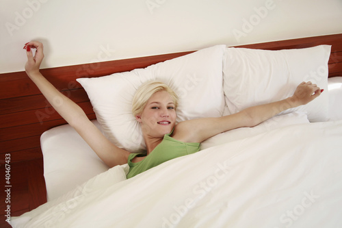 Foto: Woman stretching in bed Woman stretching in bed