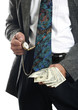 Businessman checking the time while holding cash in his hand