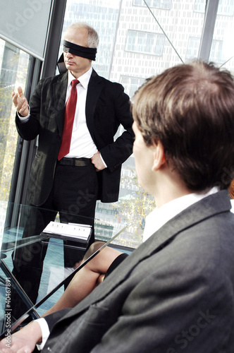 Photo: Blindfolded businessman talking in the conference room Blindfolded businessman talking in the conference room