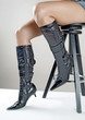 Photo: Woman in denim shorts and black boots sitting on a chair Woman in denim shorts and black boots sitting on a chair
