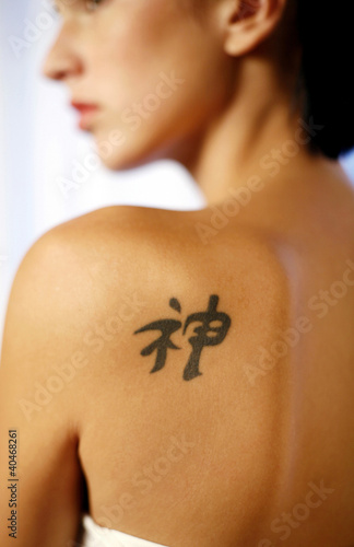 Photo: Woman with a chinese character tattoo on her back Woman with a chinese character tattoo on her back