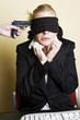 Gun being pointed at a blindfolded businesswoman