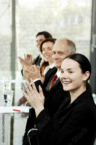 Photo: Business people clapping hands while sitting in the conference room Business people clapping hands while sitting in the conference room