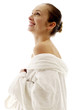 Woman in white bathrobe smiling while thinking