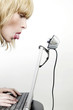 Woman sticking out her tongue at a webcam while using laptop