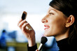 Businesswoman applying makeup