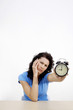 Frustrated woman showing an alarm clock