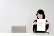 Businesswoman holding up a help me sign
