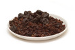 Lot of prunes, raisins on round plate isolated on white Lot of prunes, raisins on round plate isolated on white