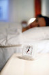 Woman sleeping on the bed with the focus on the alarm clock