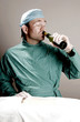 Doctor drinking alcohol in operation room