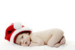 Foto: Baby in christmas hat crouching on the bed Baby in christmas hat crouching on the bed