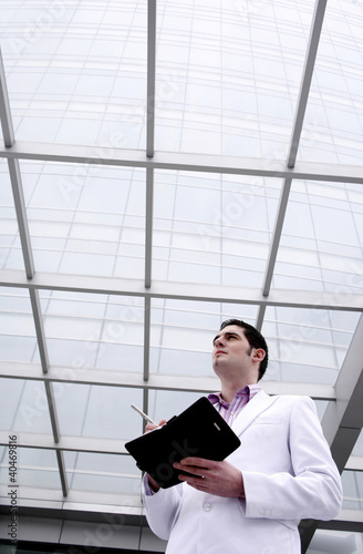 Photo: Businessman thinking while writing in organizer Businessman thinking while writing in organizer