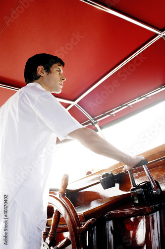 Photo: Man at helm of yacht Man at helm of yacht