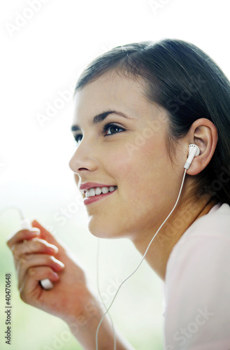 Foto: Woman listening to music on portable MP3 player Woman listening to music on portable MP3 player