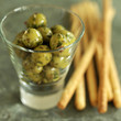 Close up of some breadsticks and a small glass of olives