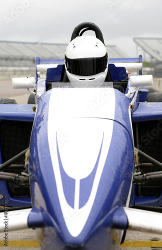 Photo: Front view of a formula one driver in racing car Front view of a formula one driver in racing car