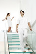Woman text messaging on the phone while her boyfriend is walking down the stairs