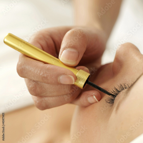 Photo: Hand applying liquid eyeliner on woman's eyelid Hand applying liquid eyeliner on woman's eyelid