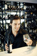 Man holding a bottle of wine and a wine glass