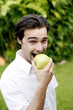 Photo: Man biting on a green apple Man biting on a green apple