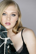 Young woman holding pearl necklace