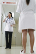 Female doctor making a call with her patient standing nearby