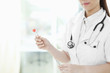 Doctor with cotton swab full of blood and a scissors