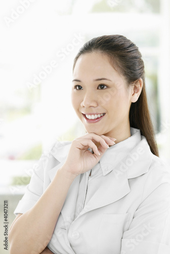 Photo: Female doctor smiling while looking away Female doctor smiling while looking away