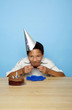 Boy with party hat eating cake