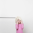 A girl (5-7) with a mop on her head
