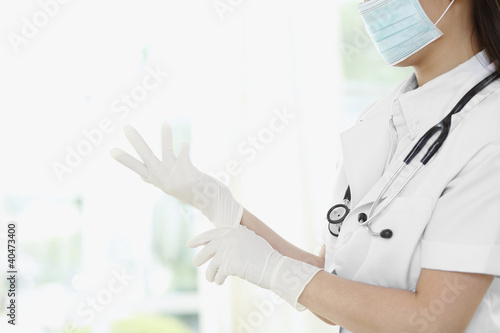 Photo: Female doctor wearing surgical gloves Female doctor wearing surgical gloves