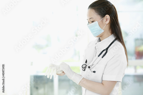 Photo: Female doctor wearing surgical gloves Female doctor wearing surgical gloves