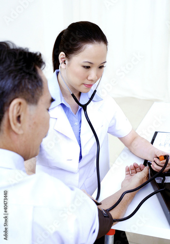 Photo: Doctor measuring blood pressure Doctor measuring blood pressure