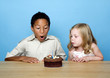 Kids blowing the candles on the birthday cake