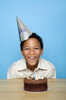 Boy posing in front of his birthday cake