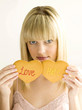 Young teen holding two cookies, love and hate