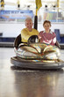 An elderly couple in a bumper car