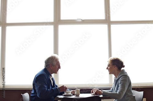 Photo: A mature couple relaxing and having coffee in a cafe A mature couple relaxing and having coffee in a cafe