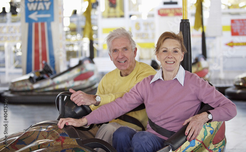 Photo: A mature couple posing for a picture in a bumper car A mature couple posing for a picture in a bumper car