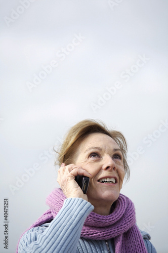 Photo: A woman smiling and talking on the mobile A woman smiling and talking on the mobile