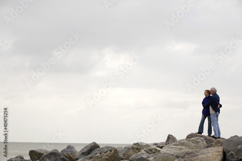 Foto: A mature couple hugging each other on the beach A mature couple hugging each other on the beach
