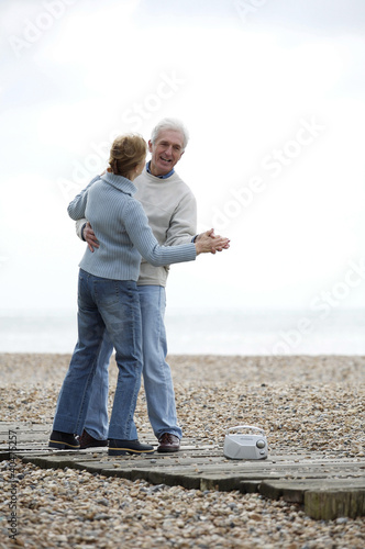 Photo: A mature couple dancing on a platform at the beach A mature couple dancing on a platform at the beach