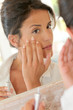 Photo: Portrait of beautiful woman applying anti-wrinkles cream Portrait of beautiful woman applying anti-wrinkles cream