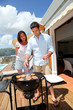 Young couple cooking dinner on barbecue grill