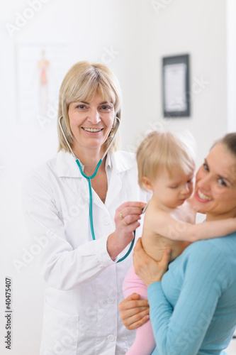 Photo: Middle age pediatric doctor examine baby using stethoscope Middle age pediatric doctor examine baby using stethoscope