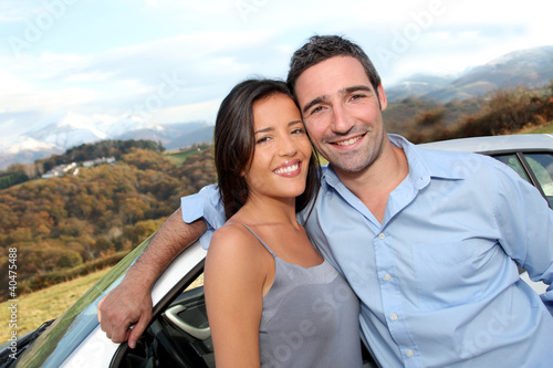 Photo: Couple standing by car on the road Couple standing by car on the road